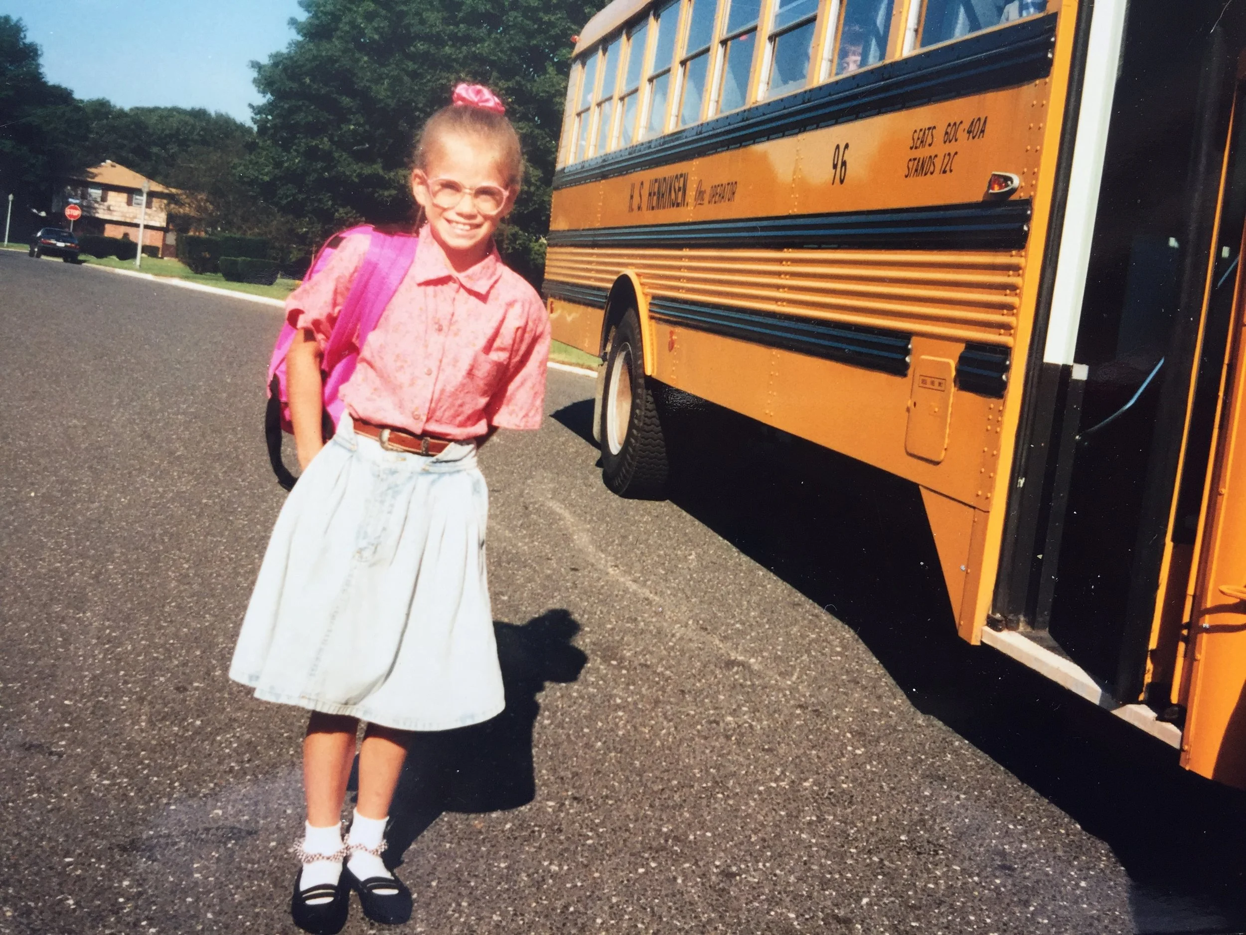 a young kadhi bo standing at a bus stop ready for elementary school