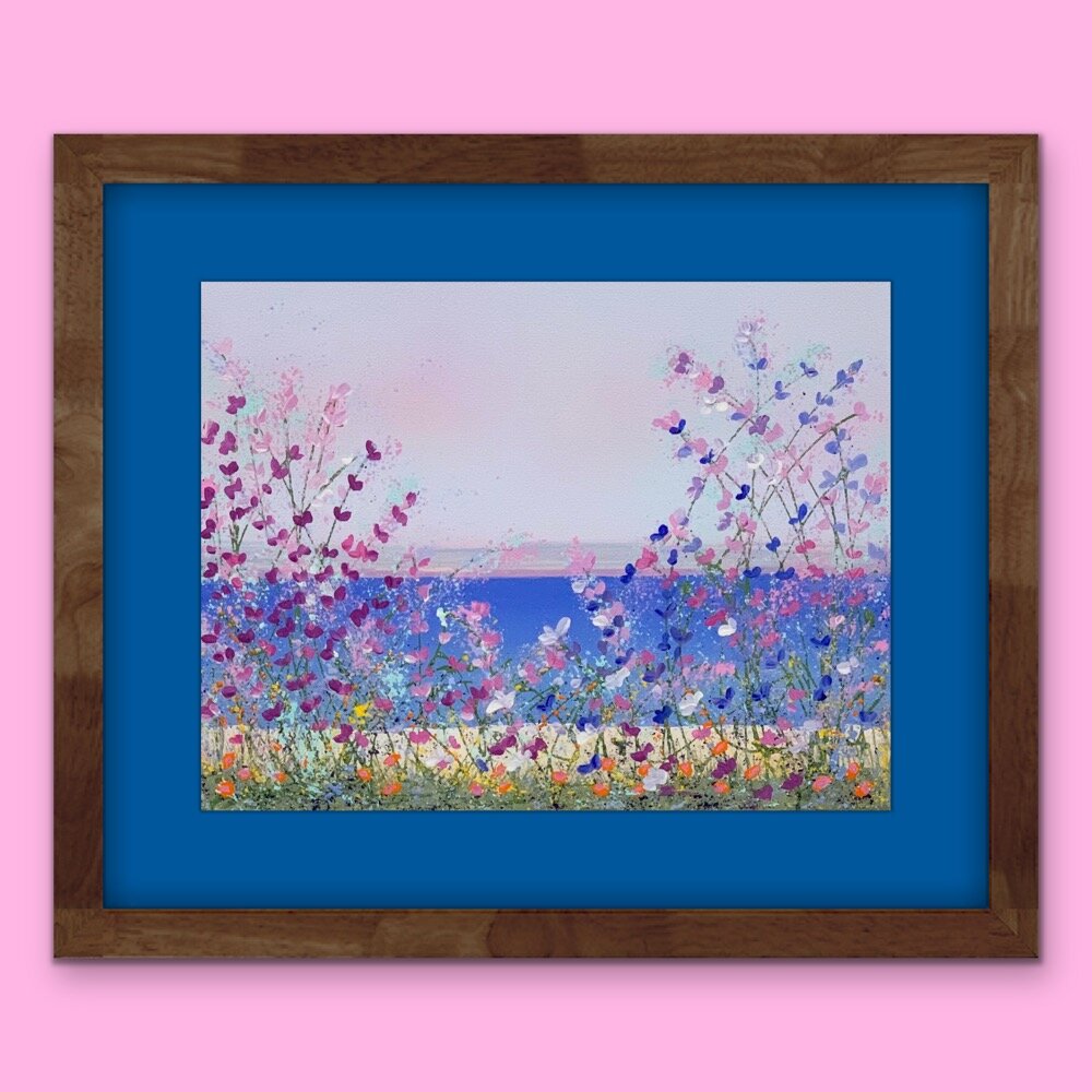 floral lakeside painting with blue mat and dark brown frame on pink wall