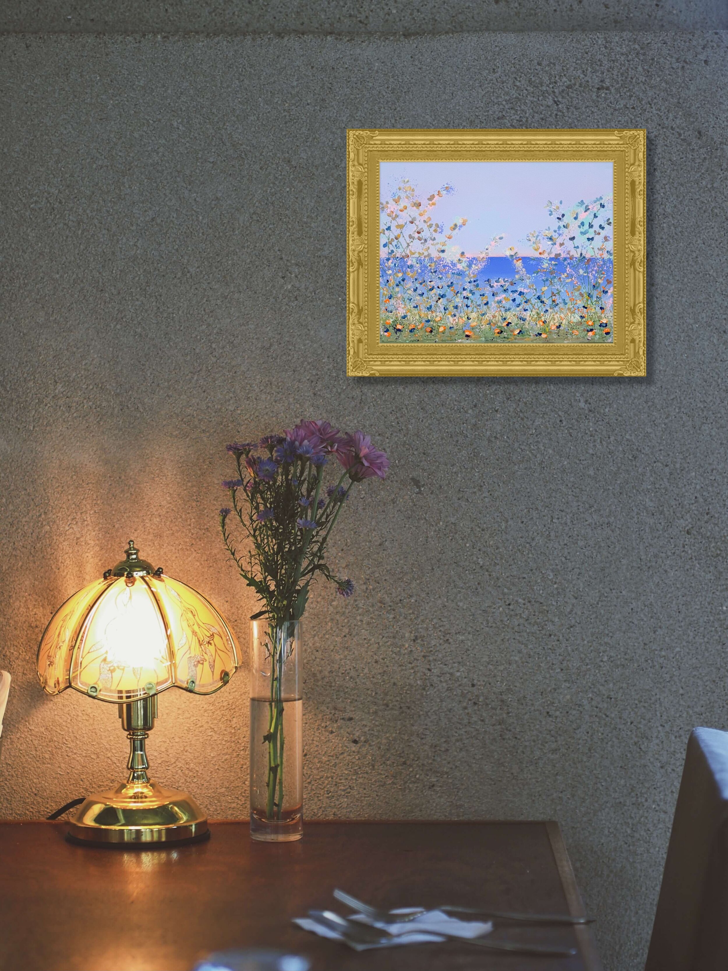 floral painting in gold frame over antique lamp