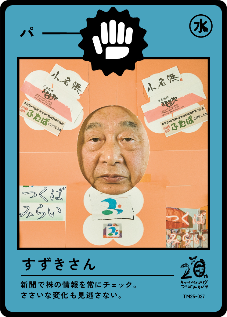 A humorous collage resembling a cartoon newspaper with a human face in the center. The background is orange with Japanese writing and various graphics, including a blue and white logo, and colorful elements. The image has various Japanese characters,