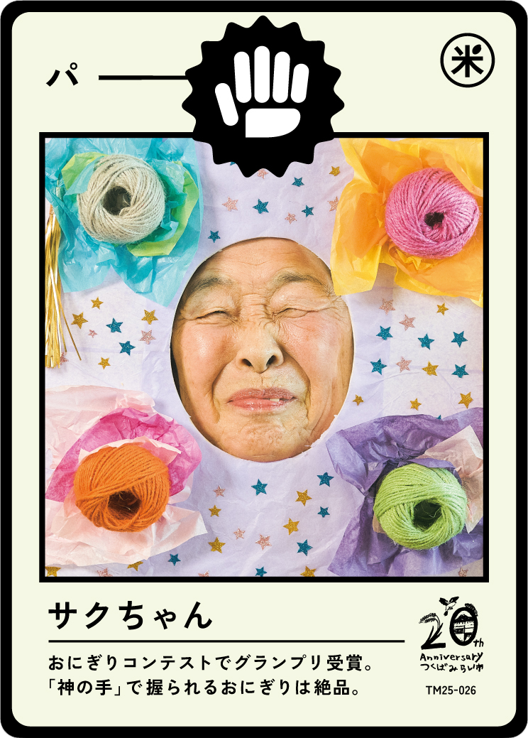 A humorous, handmade collage featuring the face of an elderly woman with her eyes closed and winking, surrounded by colorful yarn balls and tissue paper. The image is designed to resemble a traditional Japanese card, with Japanese text and some celeb