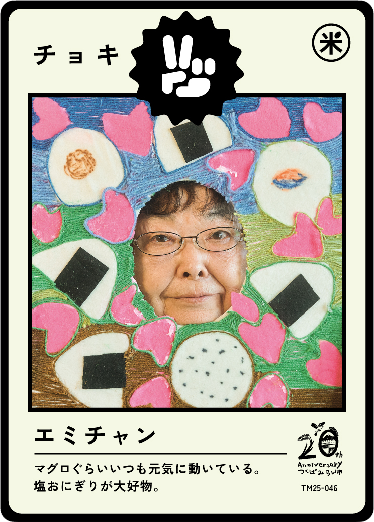 A woman peeking through a colorful, hand-drawn art frame decorated with pink hearts, rice balls, and other food illustrations. The frame is designed for a photo booth or fun display, celebrating a 20th anniversary.