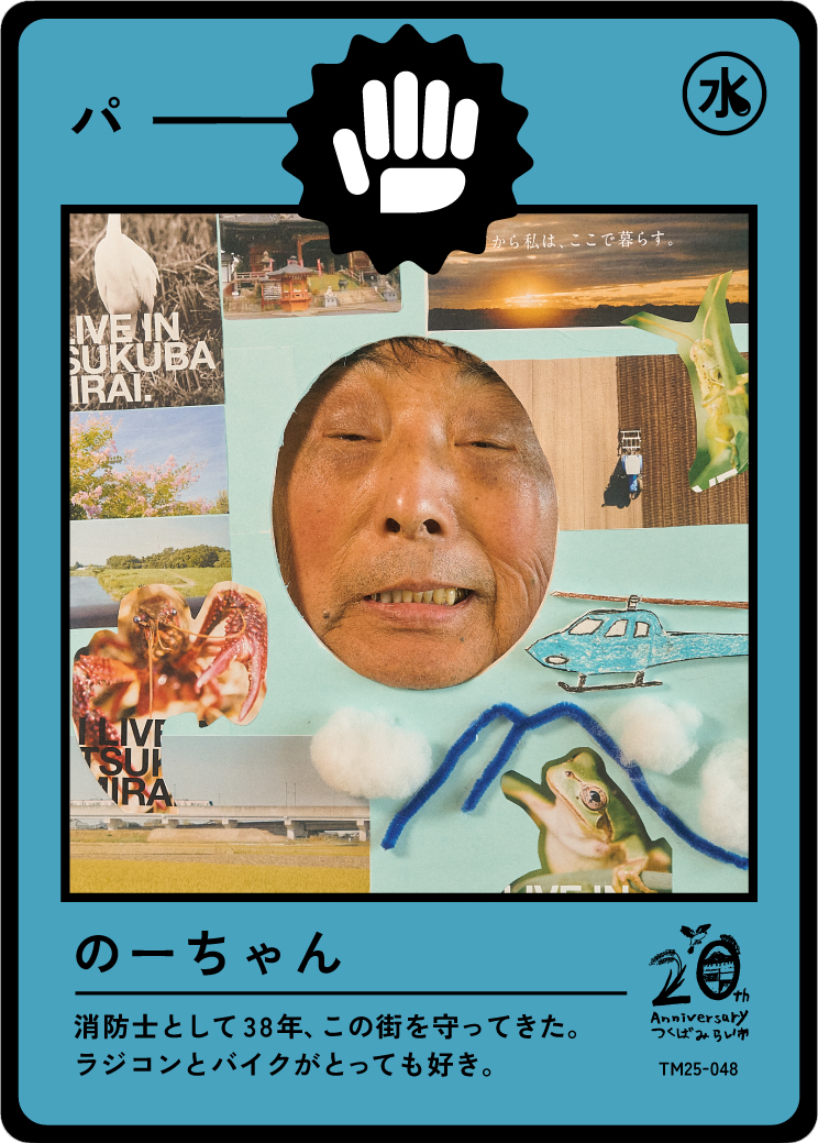 A colorful collage photo card with a person's face at the center, surrounded by images of a crane, a helicopter, a frog, a lobster, a landscape, and various Japanese and English texts. The card features a black and white symbol of a hand with a raise