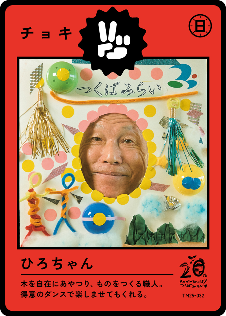 A colorful Japanese craft card featuring a man's face through a hole, decorated with various craft supplies and Japanese text, celebrating a 20th anniversary.