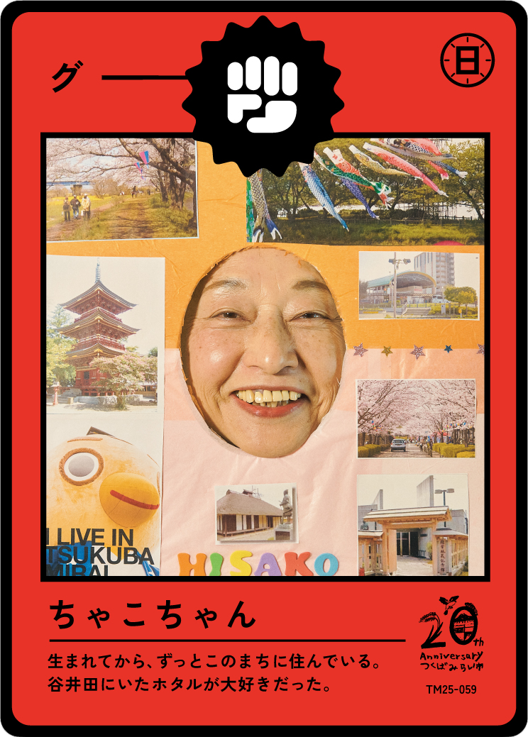 A woman smiling through a cutout in a collage board with pictures of trees, a pagoda, cherry blossoms, and landmarks from Tsukuba, Japan. The collage has Japanese text and colorful decorations.