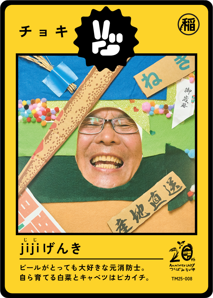 A man smiling with glasses, surrounded by colorful paper and decorations, with Japanese text and a yellow border on the card.