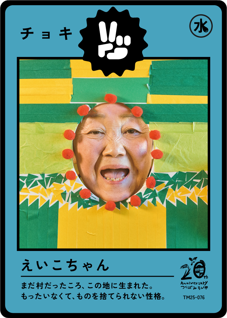 A humorous collage with a person's face inserted into a colorful paper craft decoration, resembling a character or animal, with Japanese text and symbols.