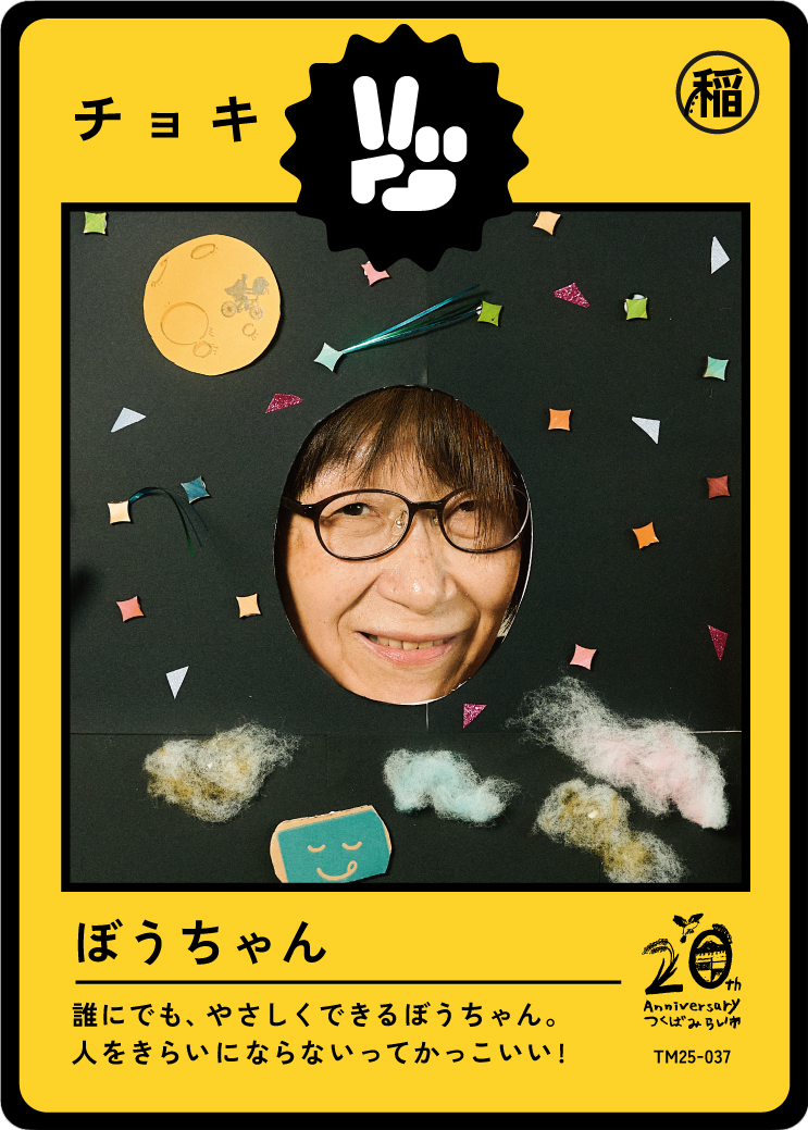 A person with glasses smiling through a paper cutout of a moon and stars on a black background decorated with small paper shapes and cotton clouds, framed as a colorful snack package celebrating its 20th anniversary.