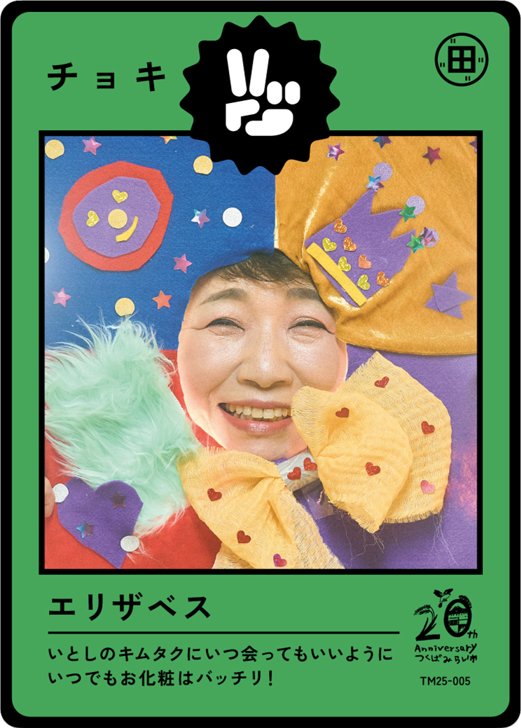 A person dressed in colorful clown or performer costume with a large smiling face, wearing a multicolored hat and bow, surrounded by confetti and decorative elements, celebrating the 20th anniversary of a company.