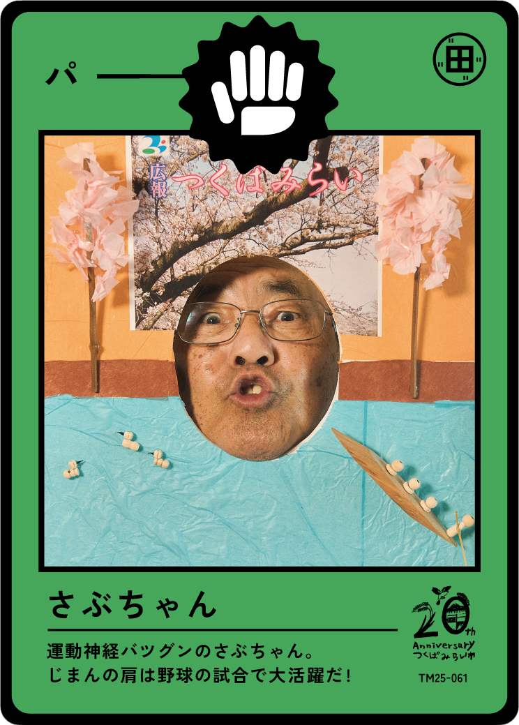 A humorous card with a man's face cut out, surrounded by paper cherry blossoms, a photograph, and Japanese text, celebrating a 20th anniversary.