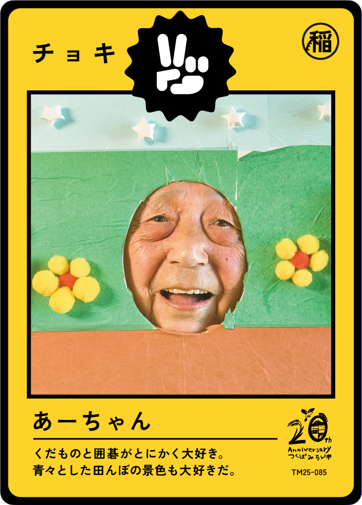 A person with a joyful face looking through a cardboard cutout decorated with paper flowers and stars, on a colorful background.