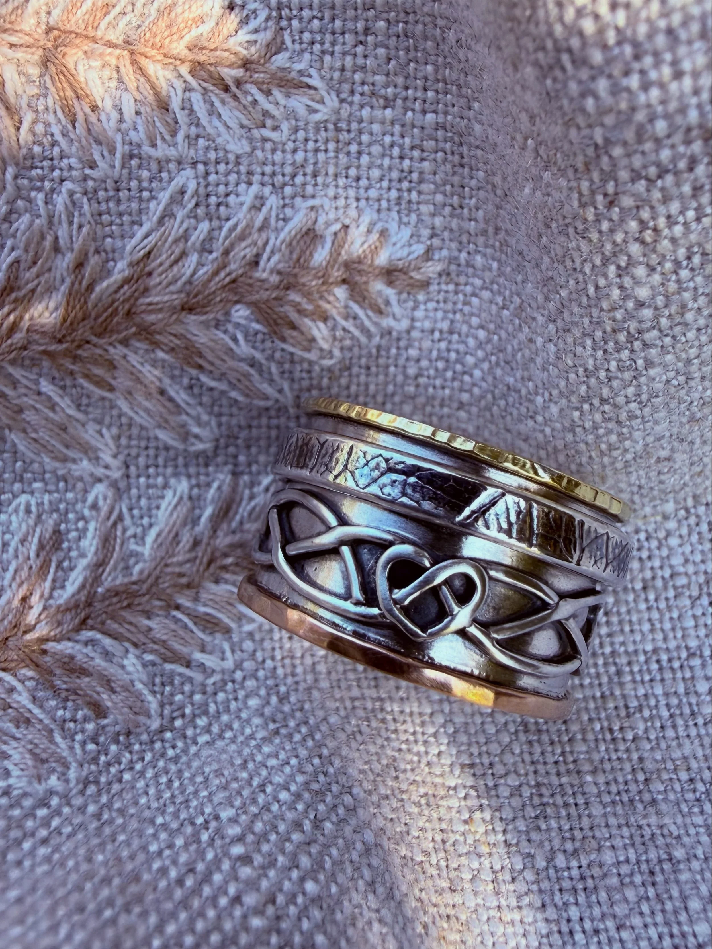 Really loved this commission, a spinner ring - sterling silver base with a meaningful weave drawn up by the client&rsquo;s daughter, spinning leaf embossed ring flanked by red &amp; yellow 18ct gold textured bands. I had several meetings with the cli