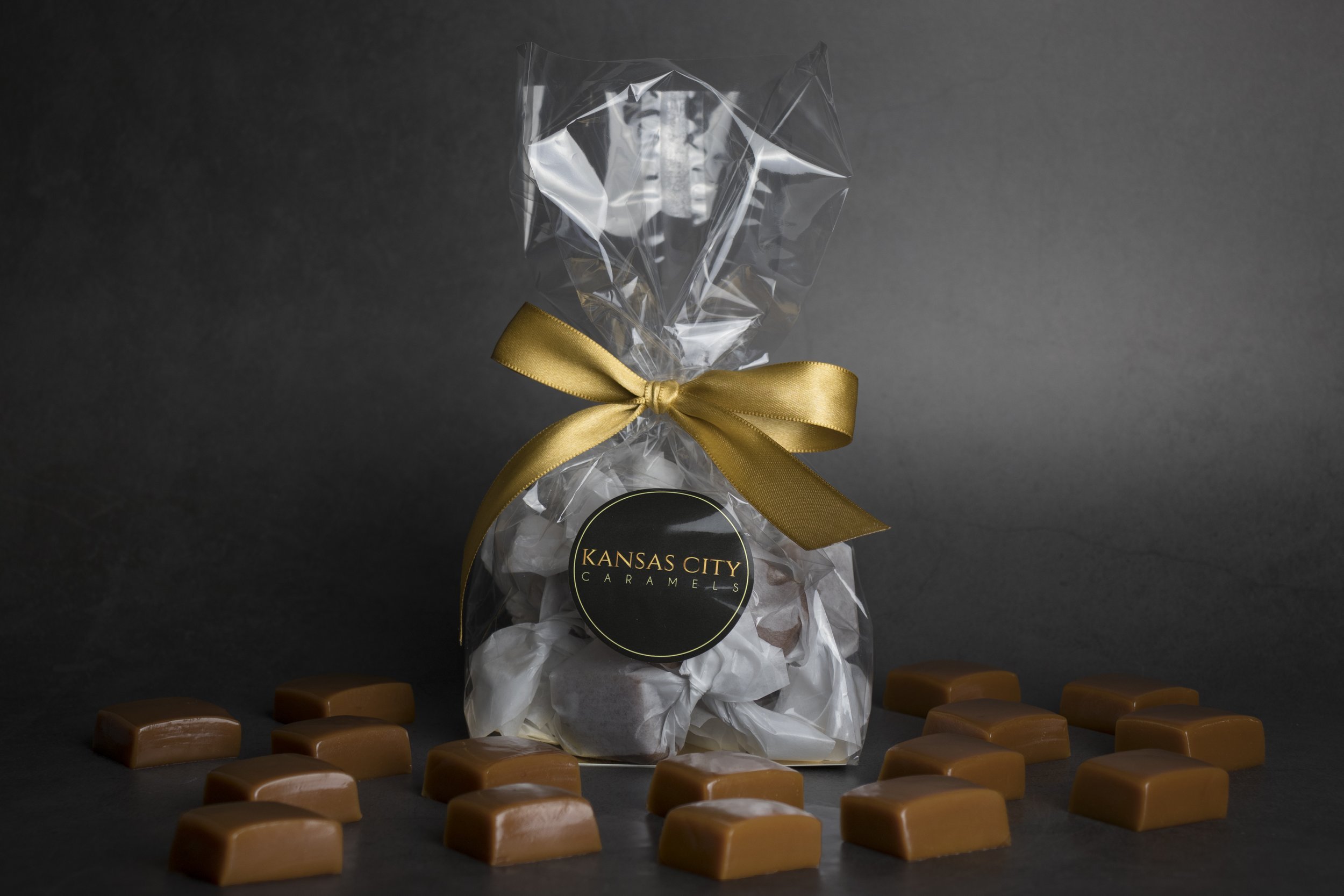 Gift bag with wrapped caramels and loose caramels on a dark background.
