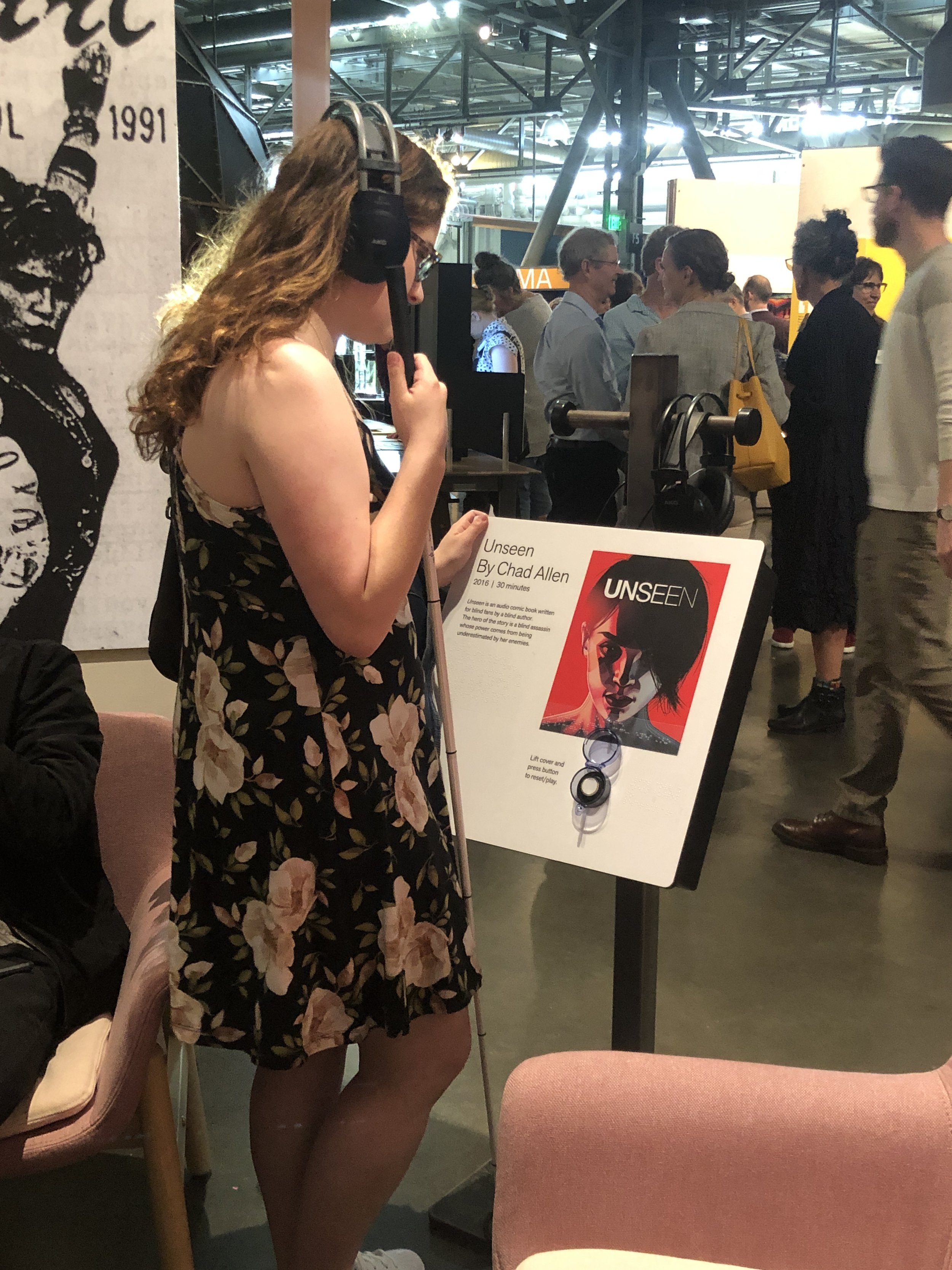 Lauren, a blind attendee listening to Unseen at the exhibit opening night