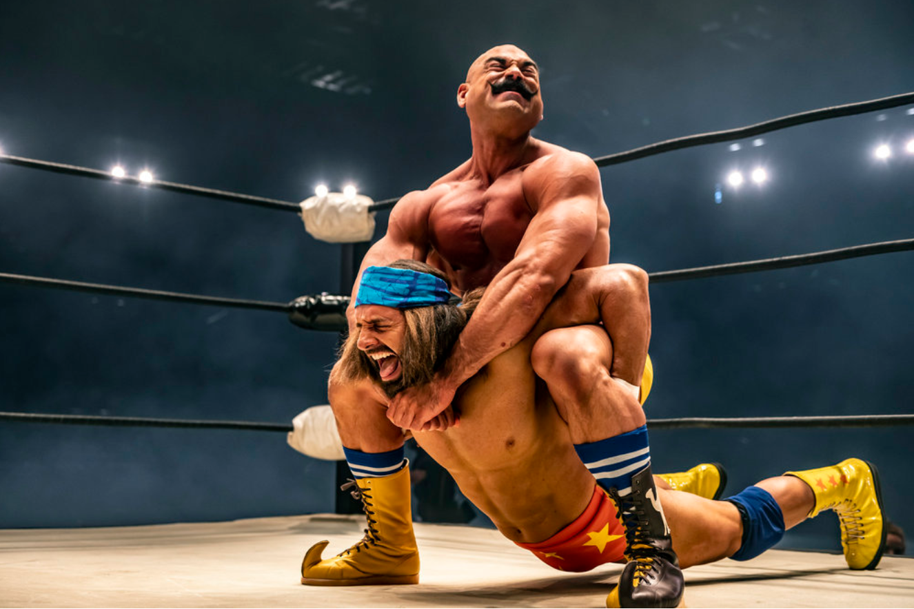 The Iron Sheik (Brett Azar) wrestling in the ring with “Macho Man” Randy Savage (Kevin Makely.)