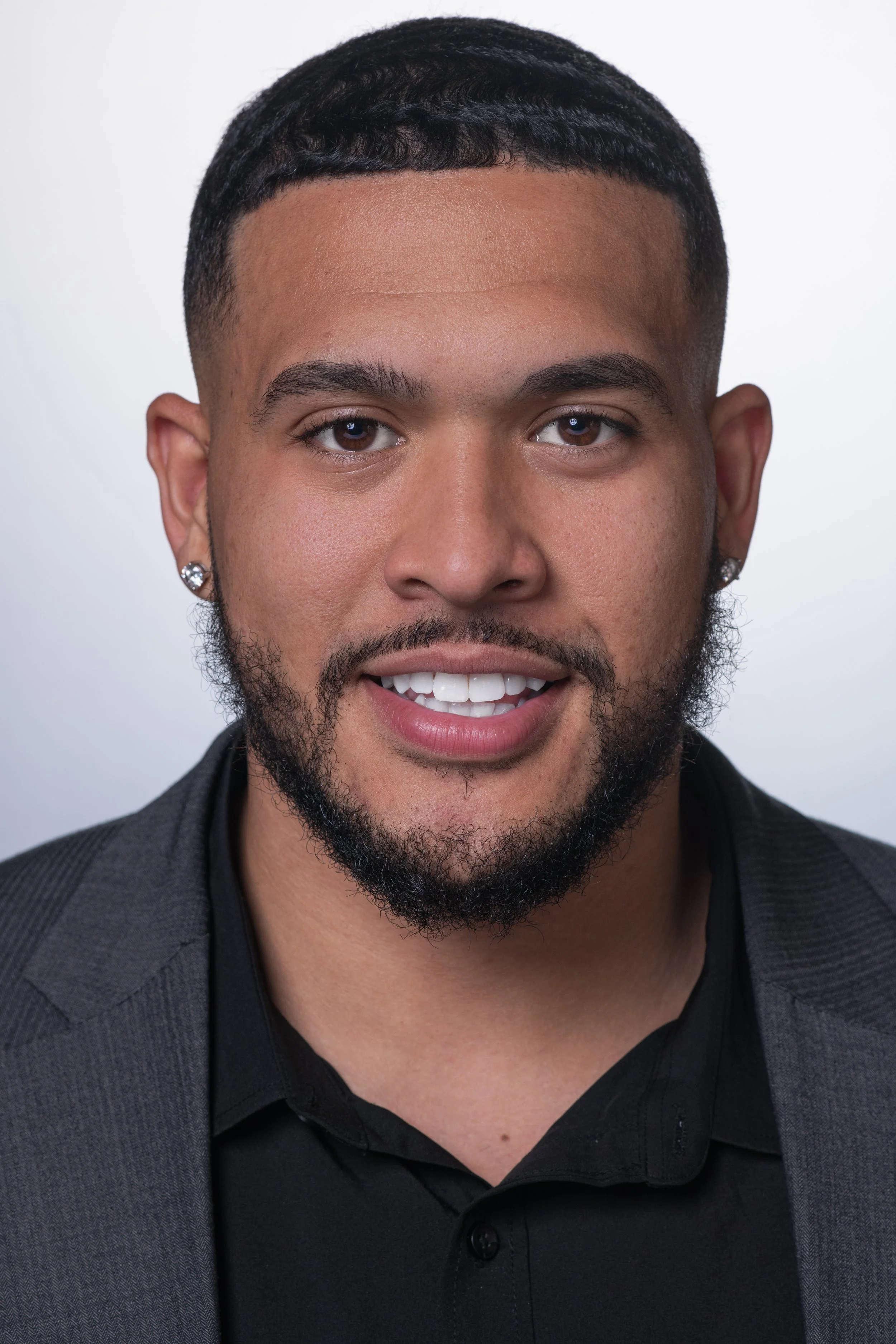Professional headshot of a man with a white backdrop facing camera directly.