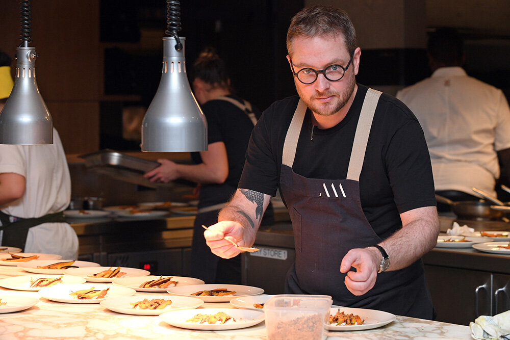 Executive Chef Clayton Wells plating up the entrée of slow cooked carrots with cumin yogurt and figs created by Kensington Street Social and served on Mud Australia plates in milk