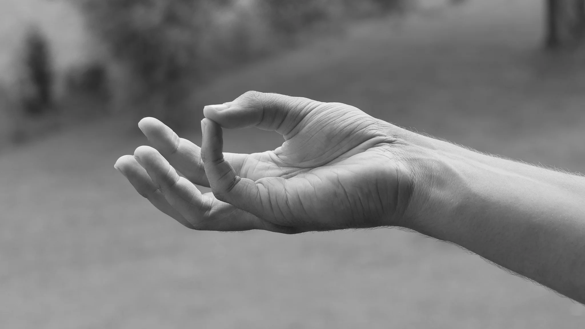 Herz-Mudra zur Aktivierung des Herzchakras mit einer roten Rosenknospe in der Visualisierung