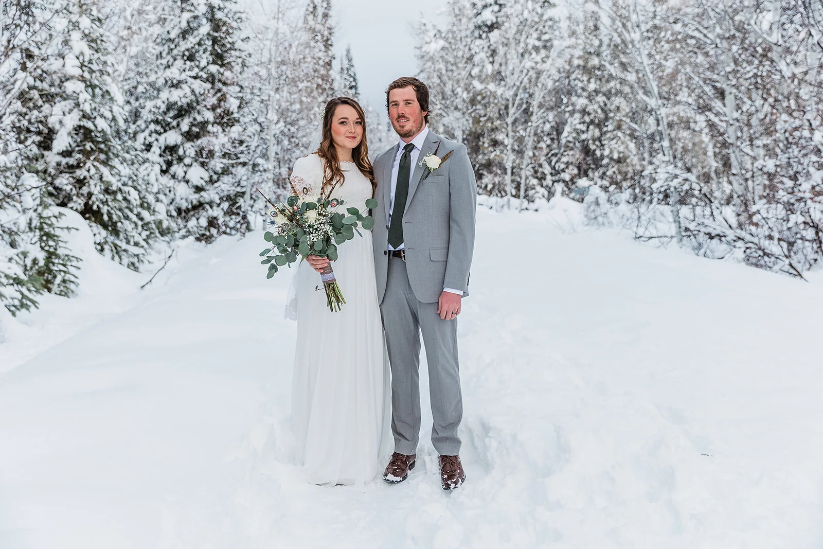 unique and interesting bouquet pheasant feathers quarter sleeve wedding dress inspiration beautiful couple mens wedding attire and outfit inspiration winter wedding dress goals winter wedding formal inspiration white and grey formals in the snow #winterwedding #formals #tony’sgrove #cachevalley #snowcoveredtrees #bellaalderphotography #professionalphotographer #winterwonderland #couplegoals #weddingattire