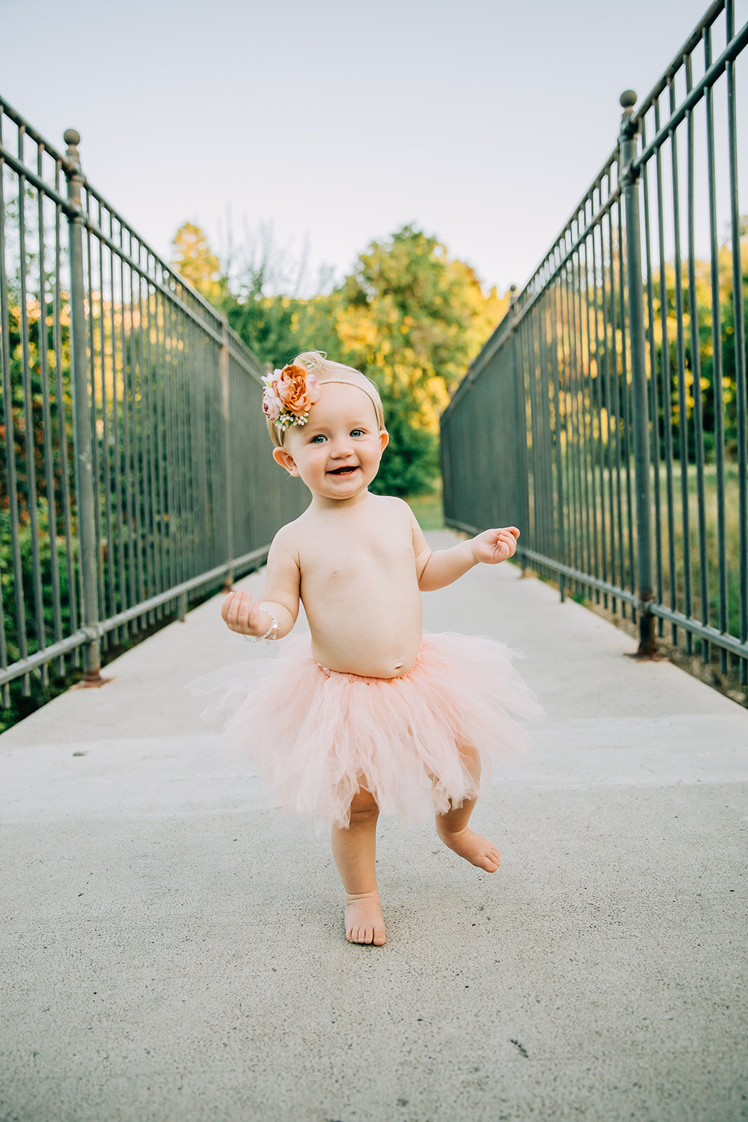  baby girl first birthday kids photography curly hair kids fashion pink tutu outfit headband inspo happy girl big smiles little fingers and toes girls day park photos baby walking photo poses first birthday posing ideas Denzil Stewart park Logan Utah