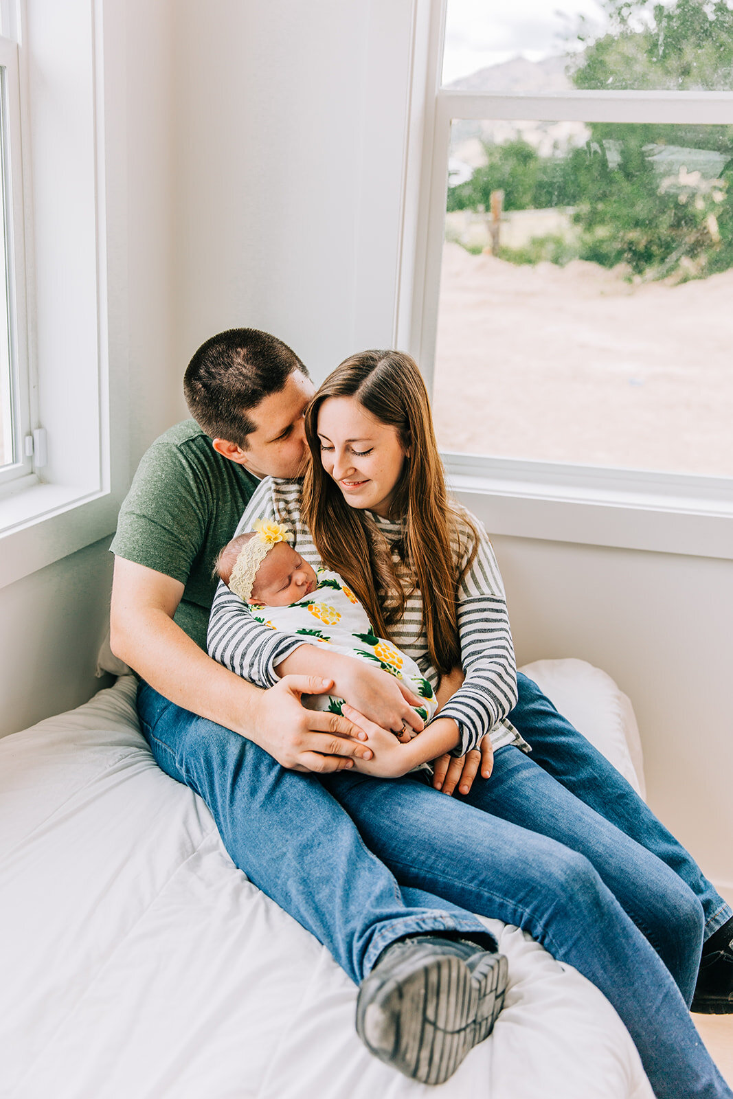  logan utah home photo shoot baby girl baby snuggles family pose inspiration fresh from heaven husband kissing wife holding baby casual posing inspiration professional photographers in cache valley family photographers in logan newborn photo shoot fa