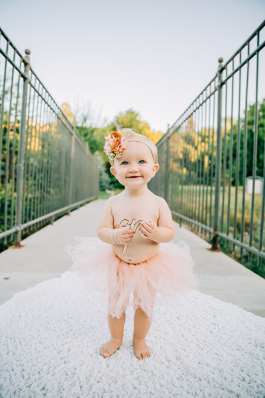  kids photography standing on a blanket baby prop ideas birthday shoot wooden props hand held props baby dancer outfit inspo floral headband inspo what to wear to birthday shoot first birthday smiling girl cute baby cache valley photographer Denzil S