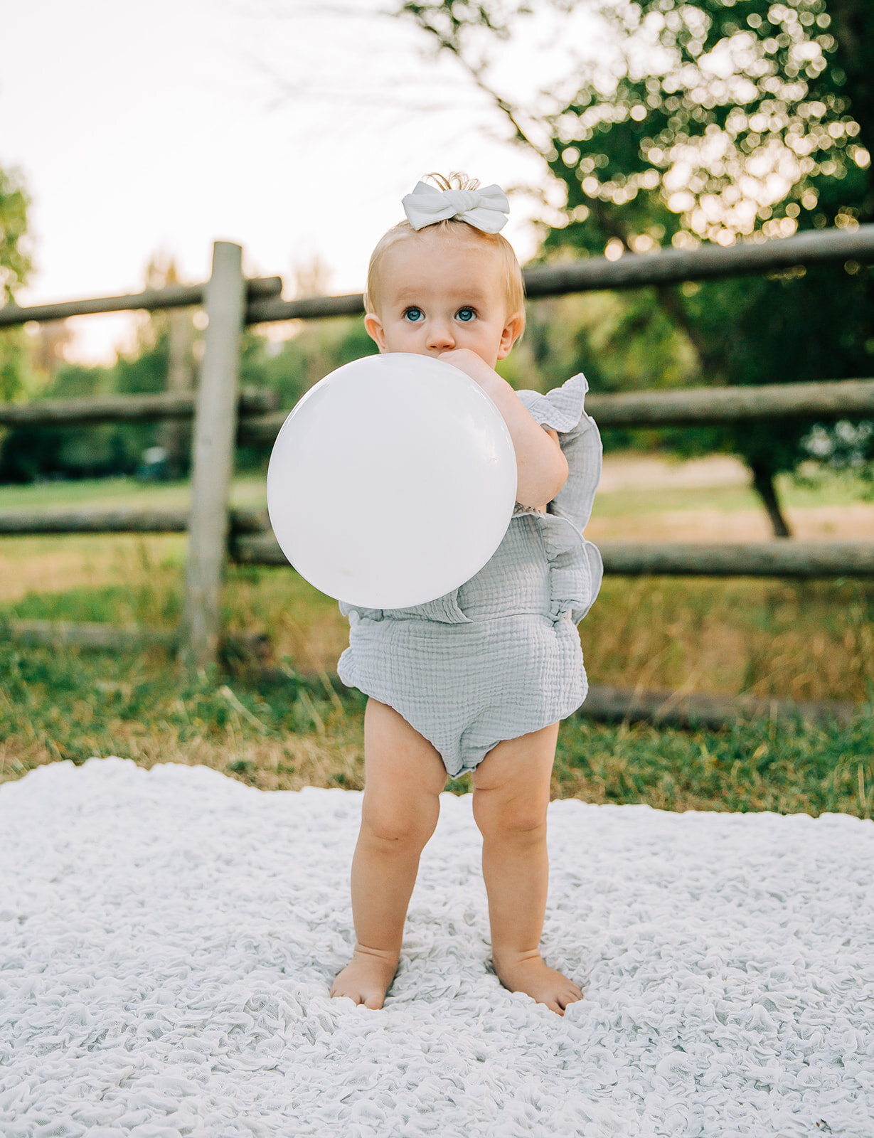  kids outfit inspo first birthday picture ideas birthday girl party ballon baby blowing up ballon kids fashion ideas what to wear to baby photoshoot hair bow inspo prop ideas for kids Logan Utah cache valley photographer baby girl turning one big blu