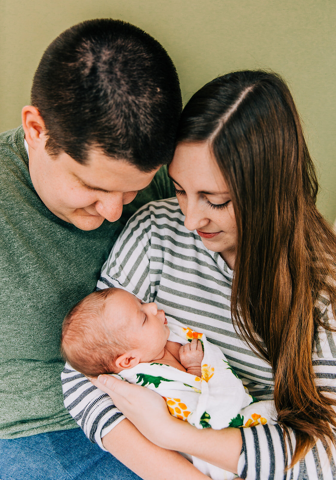  family of three professional family photographers in cache valley newborn photography baby makes three mom and dad cuddling baby pose inspo casual family photo shoot precious memories sweet baby cute newborn pictures logan utah professional photogra