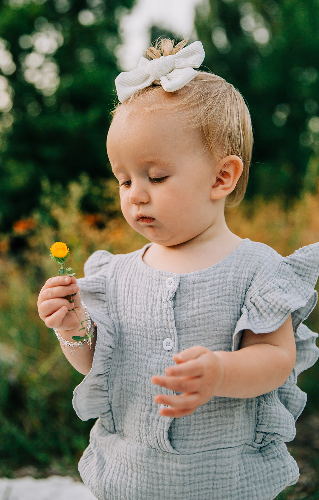  happy birthday birthday girl baby turns one baby fashion inspo baby hairstyle ideas clothing ideas for baby girls picking flowers at the park wild flowers and tall grass colorful flowers baby posing inspo kids fashion inspo Denzil Stewart park baby 