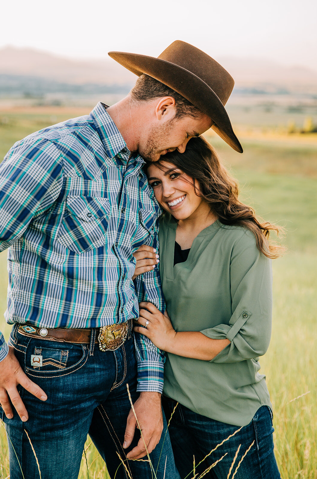  country lovers cowboy outfit inspo forehead to forehead intimate posing couple posing ideas engagement session summer time green grass blue and green outfit ideas girl looking at photographer in love couple swing dancing partners future farmer hat s