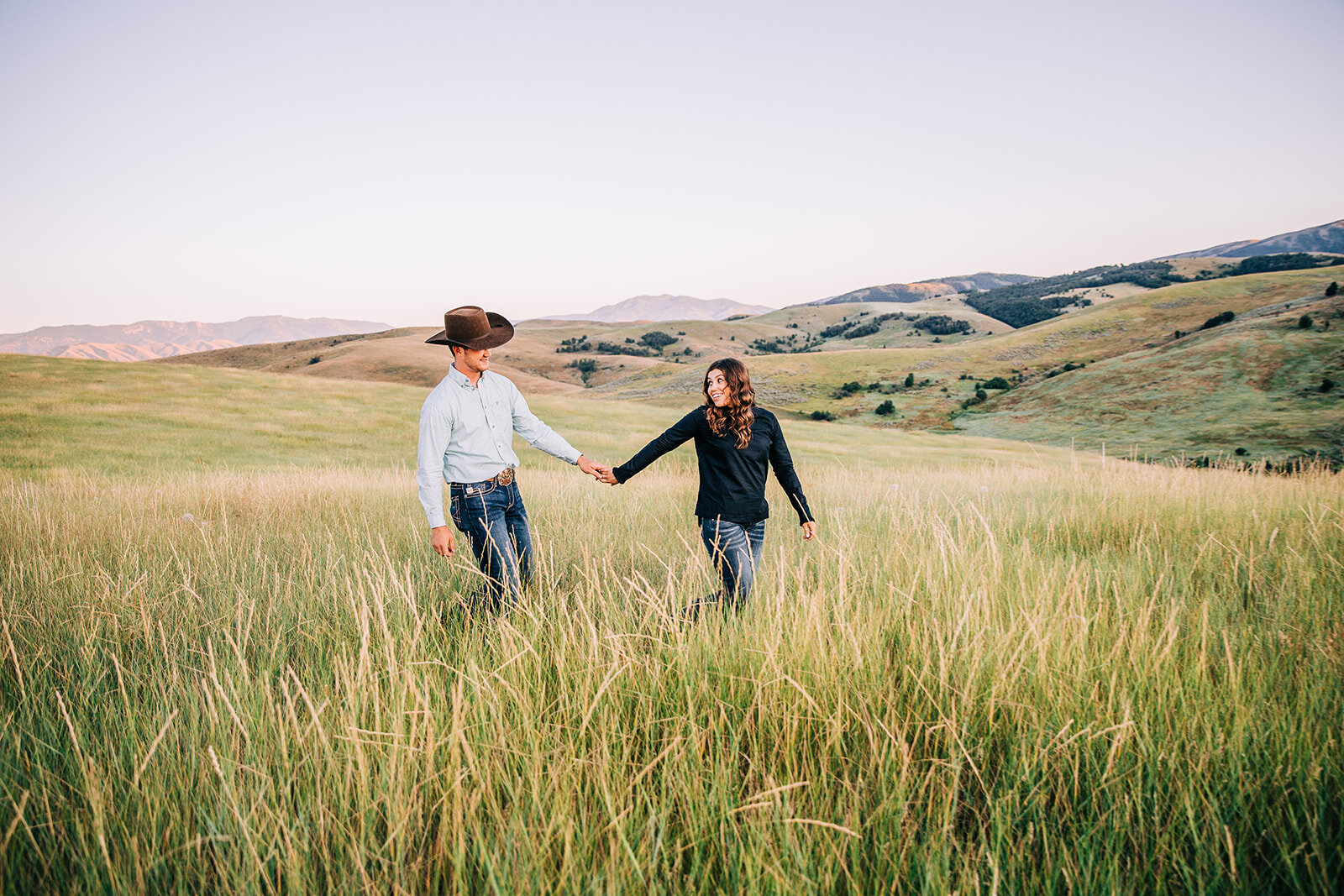  happy couple blue jeans semi-formal attire country engagement outfit inspo lead me poses holding hands couple posing ideas engagement posing inspo walking together hairstyles for women future husband and wife summer sun paradise Utah cache valley ph
