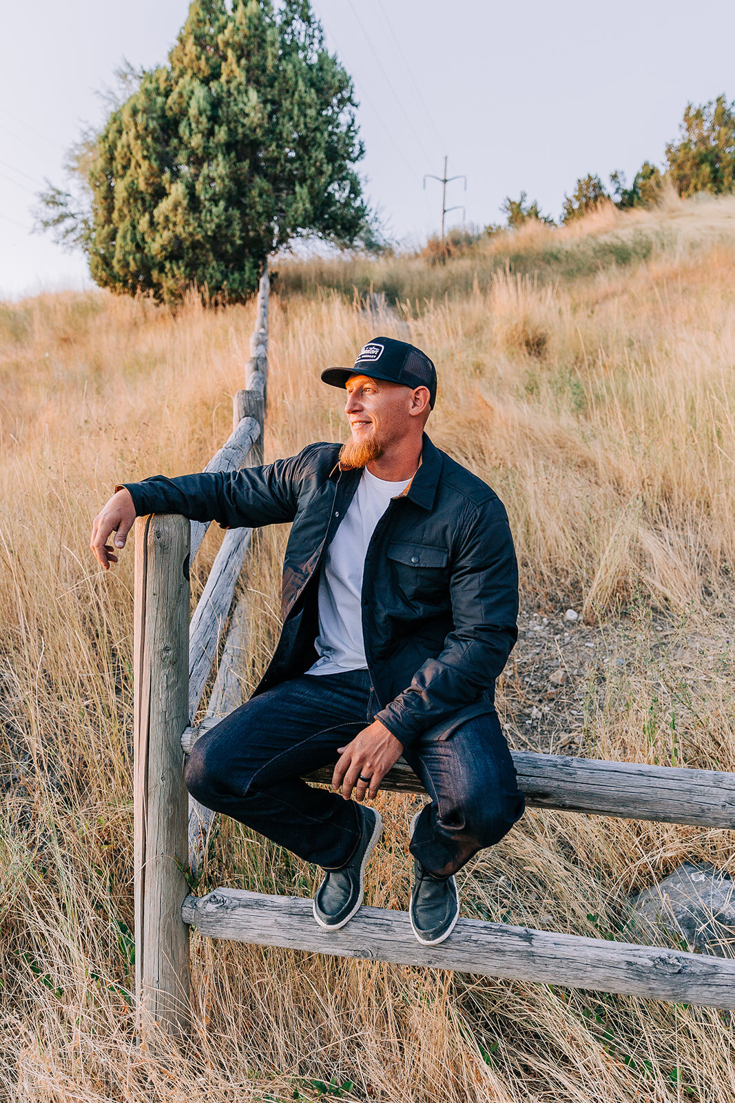  male model clothing model middle age clothing model northern utah red bearded online fashion boutique clothing tremonton utah professional photos leather jacket sitting on a fence commercial photoshoot bella alder photography northern utah fashion p