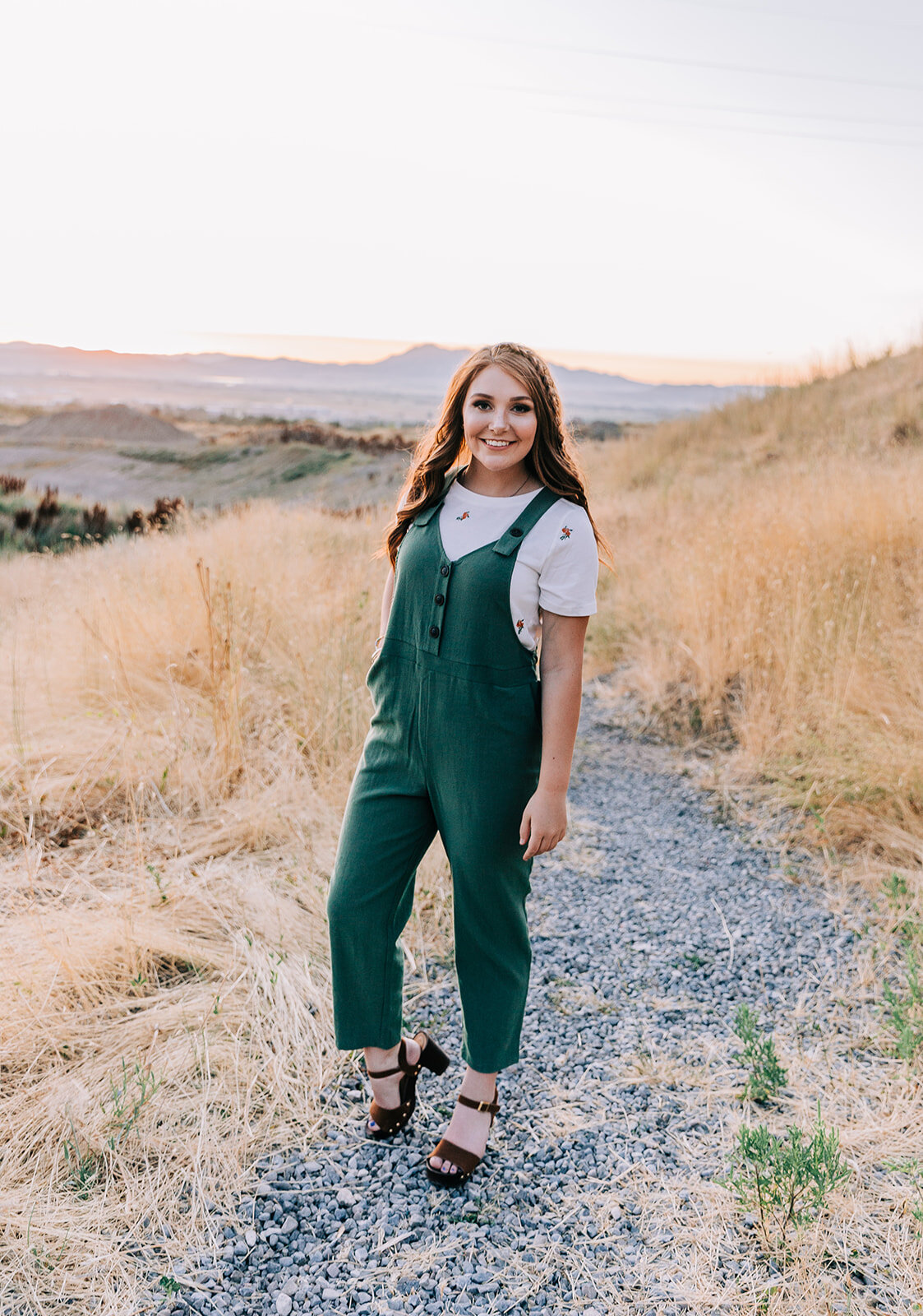  brunette fashion model young woman photoshoot for clothing boutique in tremonton utah green jumper overalls with white tee underneath women's fashion fashionable clothing style in northern utah photos by bella alder photography professional clothing