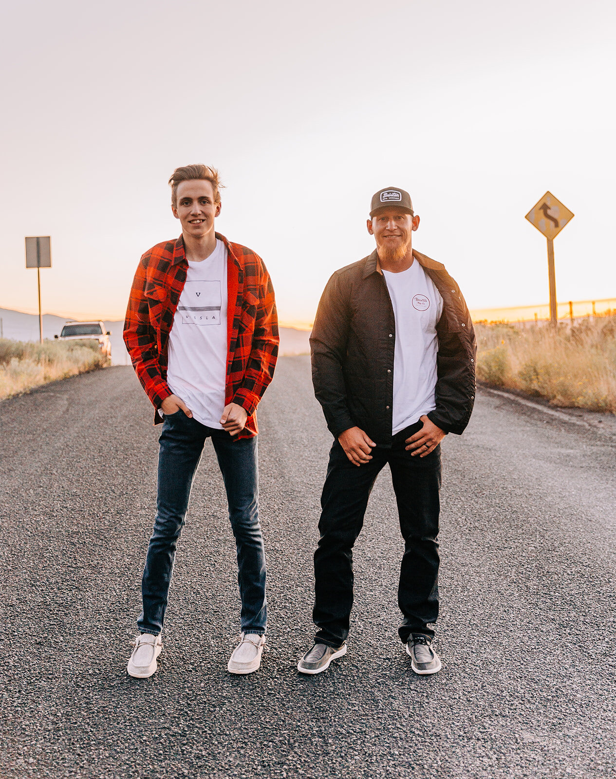  men standing in the road male models white tees with red and black plaid button up top and leather jacket baseball cap men’s clothing fashion shoot photos by bella alder photography northern utah commercial photographer in cache valley online clothi