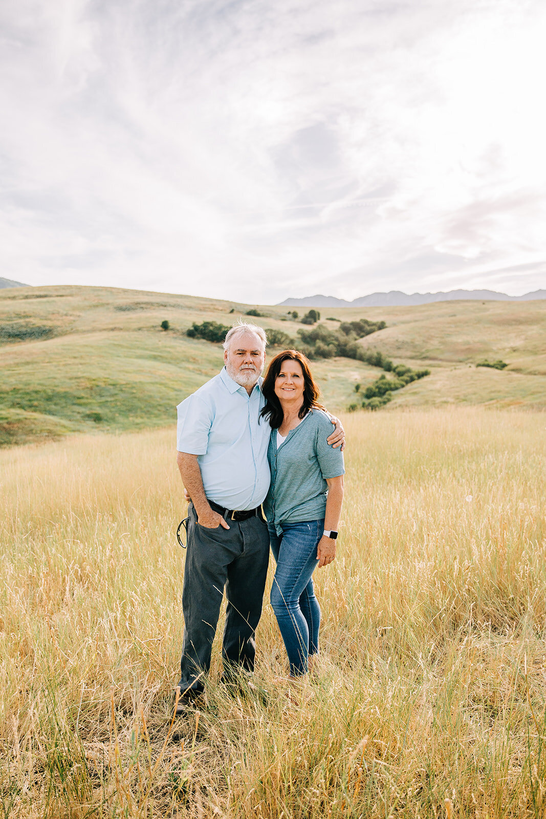  extended family photos mom and dad yellow fields rolling hills beautiful location in hyrum utah for family pictures blue shirt shades of blue coordinating outfits matching outfits for family photos by bella alder photography grandma and grandpa posi