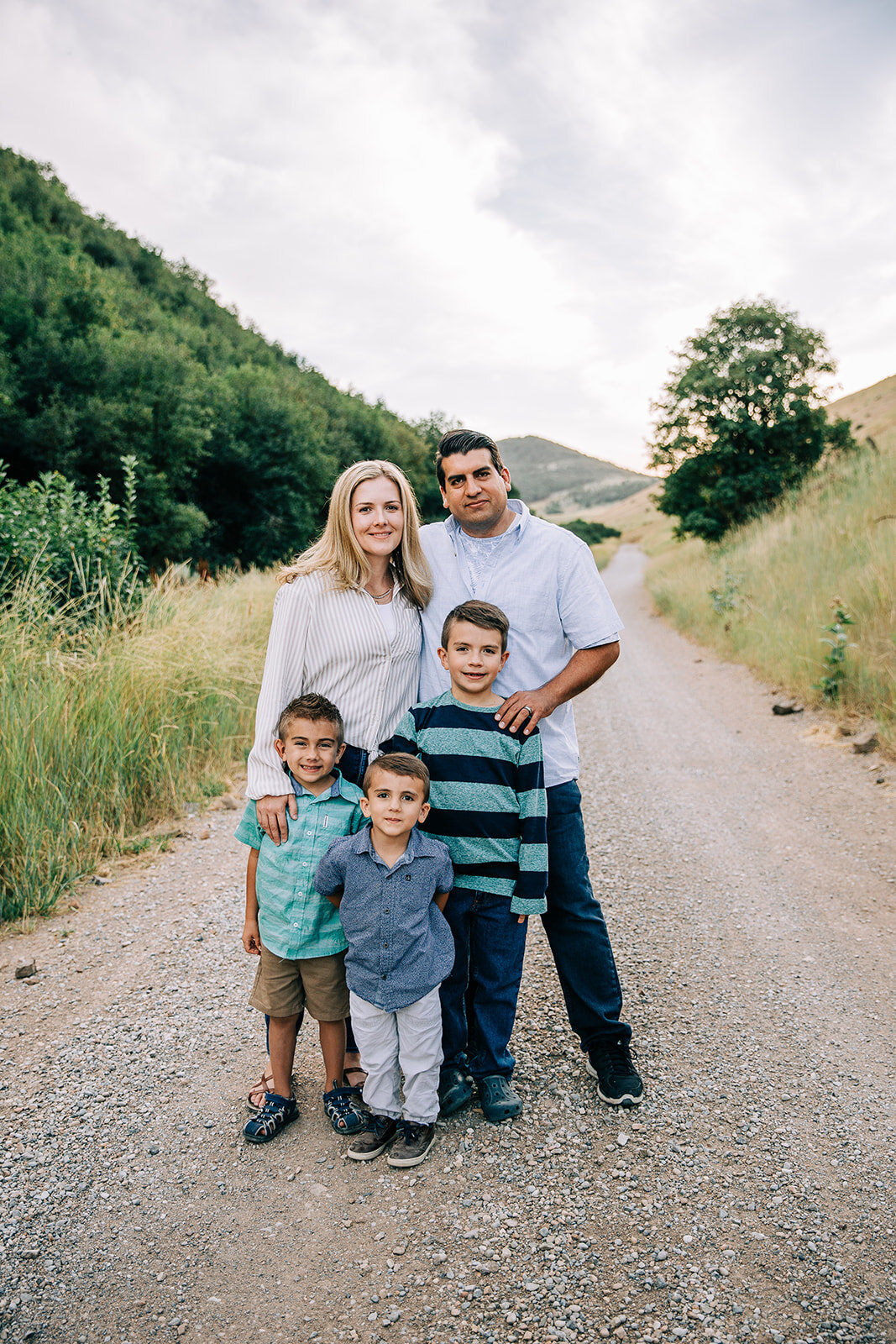  family posed together for family photos extended family pictures by bella alder photography family posing on a road mom dad and three sons navy and mint stripes shades of blue outfit ideas for coordinating outfit inspo for family pictures in hyrum u