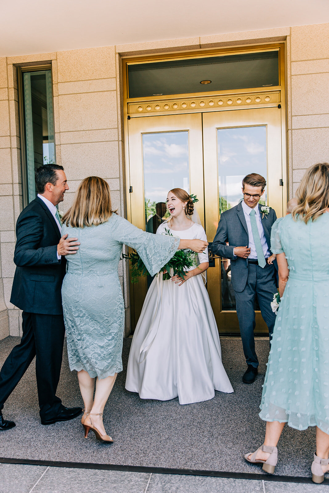  bride hugging her parents after leaving the temple professional lds wedding photographer available for travel affordable wedding day photos salt lake city utah modest bride oquirrh mountain temple wedding photos summer wedding inspiration light blue