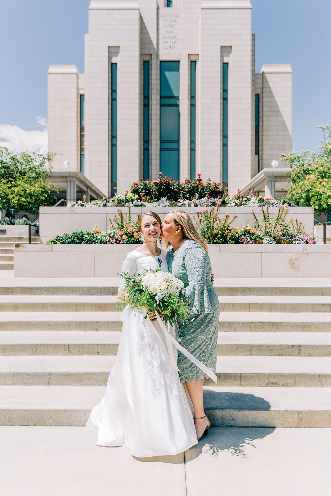  bride posing with her mother outside the temple mormon wedding professional wedding photographer friends and family pictures outside the temple after the sealing here comes the bride say yes to the dress just married she said i do summer wedding sun