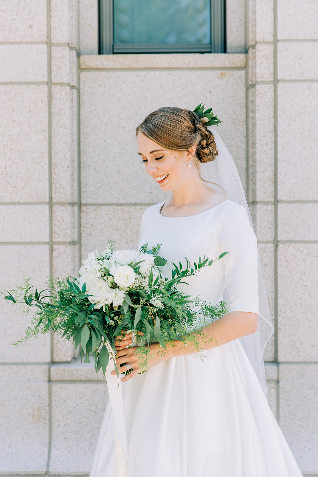  lds bride wedding hair and make-up inspiration for summer wedding white and green floral bouquet with lots of greenery floral inspiration in hair wedding updo long veil elbow-length sleeves modest wedding gown pictures after the sealing outside the 