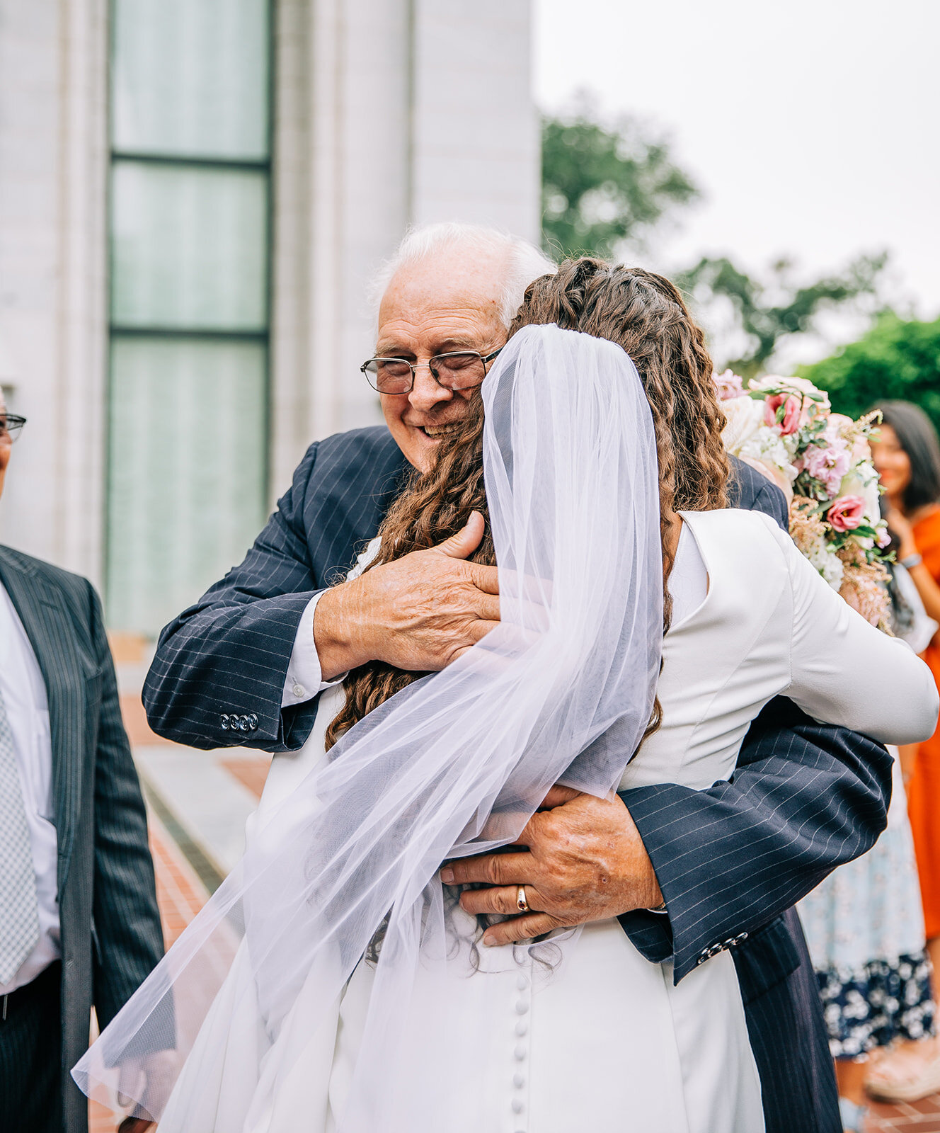  bride hugging her grandfather outside the temple on temple square salt lake city utah wedding mormon bride mormon wedding lds couple affordable utah wedding photographer salt lake city bella alder photography long veil wedding style inspo for young 