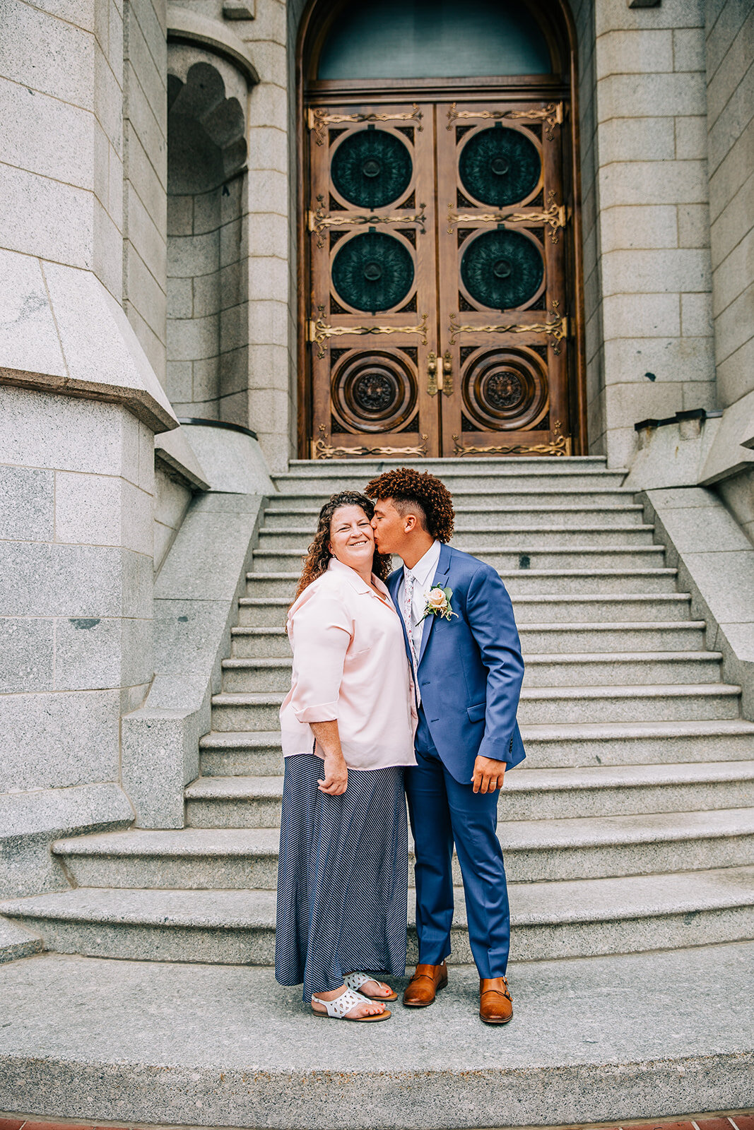  groom kissing his mom on the steps outside the temple lds wedding sealing ceremony groom in a blue suit groom style inspiration affordable wedding photographer available for travel outside of salt lake city utah wedding photography bella alder #bell