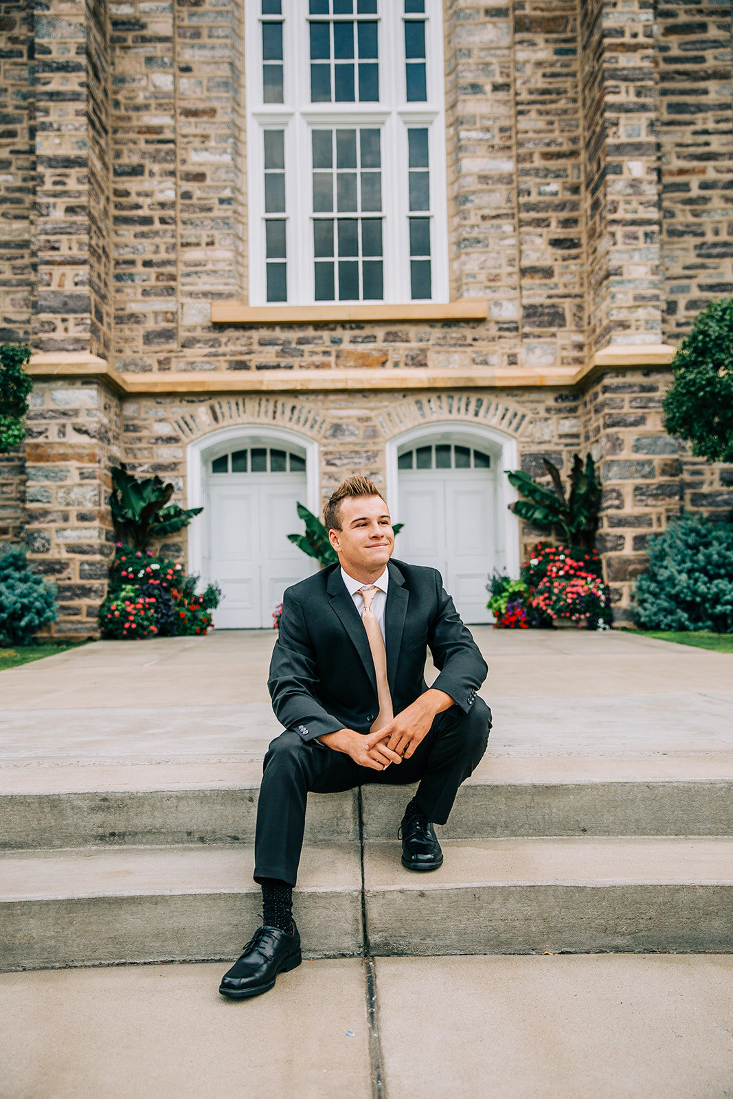  young man sitting on steps outside logan utah lds temple missionary black suit blush tie cache valley missionary photos professional headshots for elder pritchett missionary photos post idea logan utah bella alder photography #bellaalderphoto #missi