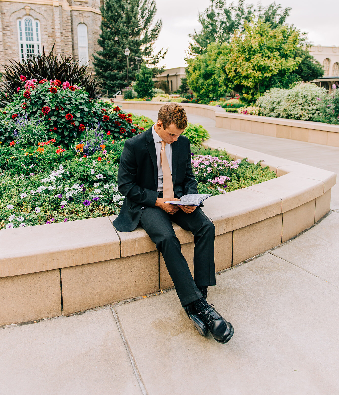  young man black suit classy portraits missionary headshots pose idea missionary studying his scriptures reading scriptures outside the logan utah lds temple book of mormon preach the gospel bella alder photography professional missionary photos #bel