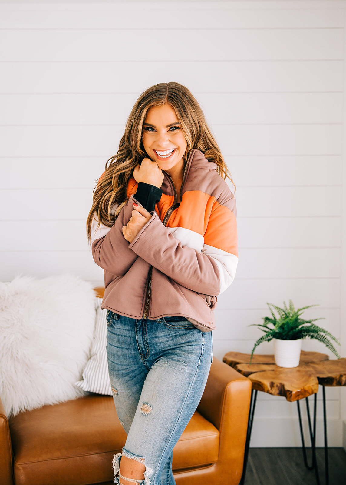  distressed light wash jeans puffy hoodie color block jacket beachy waves light brown hair gorgeous model brilliant smile natural light studio logan utah product photography standalone model pose ideas for commercial photography product photos online