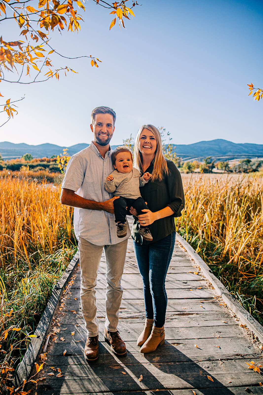  family of three boardwalk family pictures garden city park bear lake utah together again grandkids grandson mom and dad holding baby fields of gold mountains lakeside photos professional photographers in utah utah family photographers extended famil