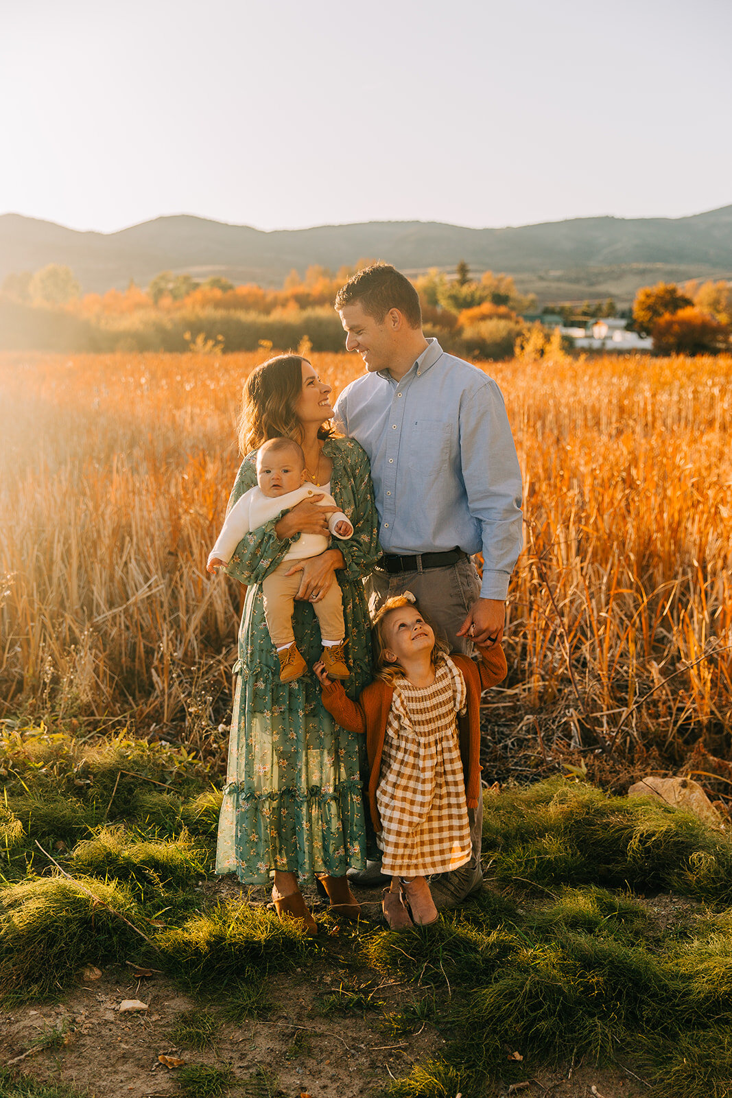  man smiling at woman daughters family of four boardwalk family pictures garden city park bear lake utah together again fields of gold mountains lakeside photos professional photographers in utah utah family photographers extended family siblings fam