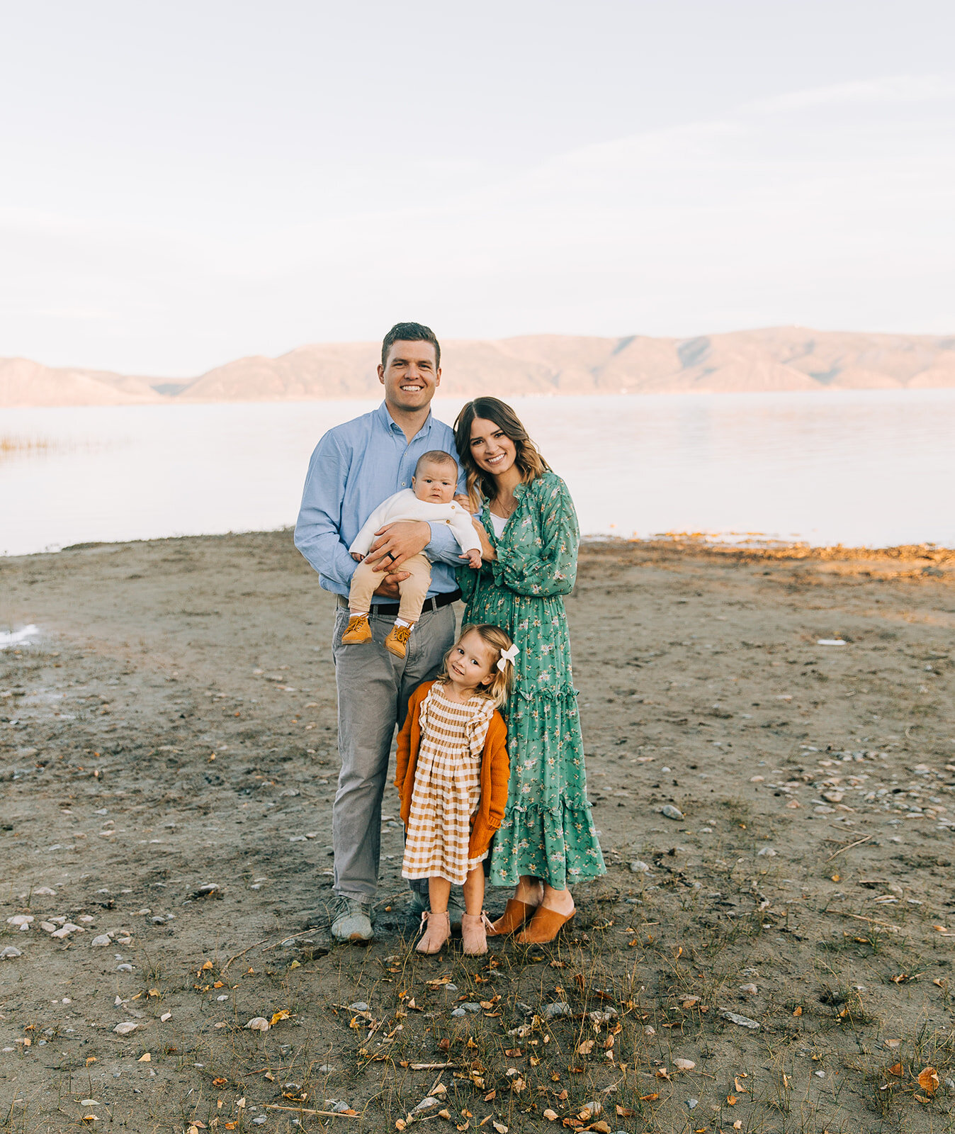  man and woman hugging and holding their children family pictures garden city park bear lake utah together again fields of gold mountains lakeside photos professional photographers in utah utah family photographers extended family siblings families a