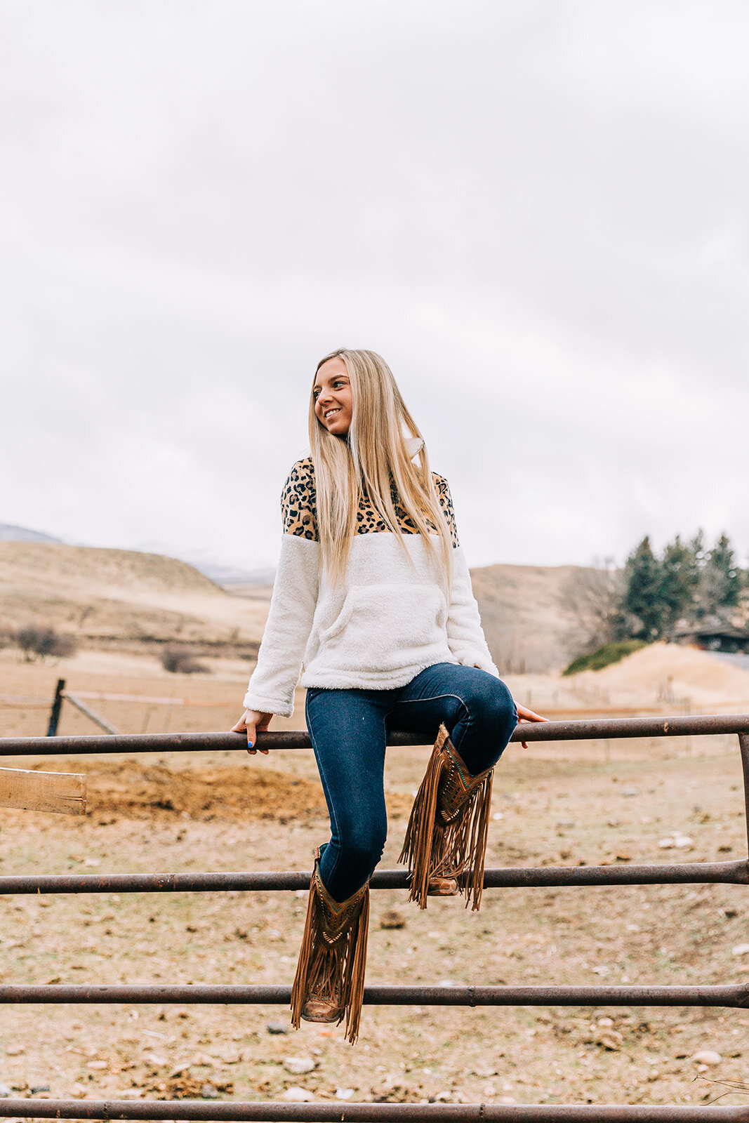  color block sweatshirt cheetah leopard print tassel boots jeans sitting on a fence long hairstyles hair and makeup inspiration country style professional photographers in utah commercial photographers in utah horses wild rag boutique commercial phot