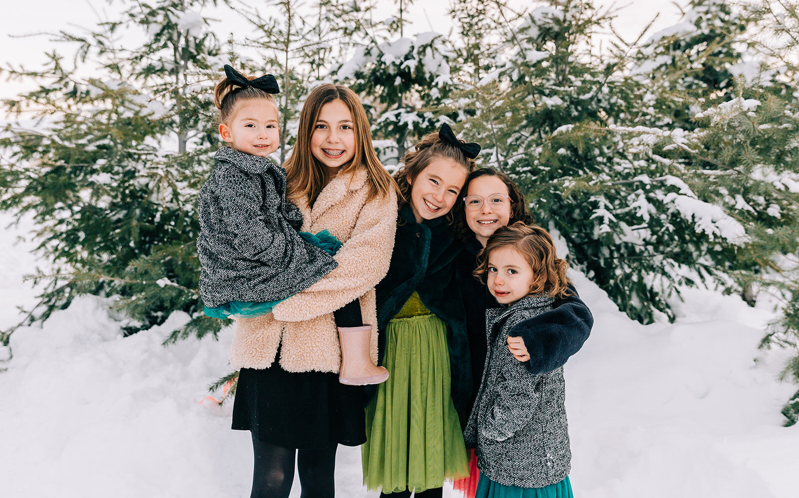  sisters hugging and smiling five daughters family pictures daughters kid fashion family picture styling inspiration family pose ideas winter photoshoot snowy pictures adams acres tree farm family photographers in utah professional family photographe