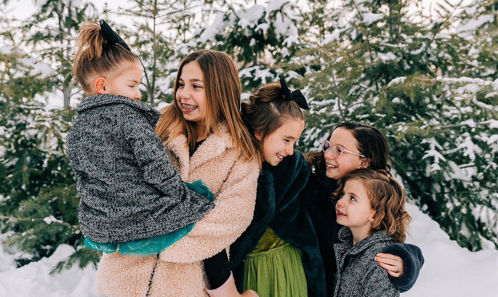  five daughters sisters hugging and smiling family pictures daughters kid fashion family picture styling inspiration family pose ideas winter photoshoot snowy pictures adams acres tree farm family photographers in utah professional family photographe